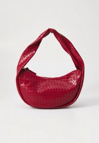 Rode geweven tas met een afgeronde vorm en een gedraaide handgreep; glanzende afwerking; voorzien van een ritssluiting en een gestructureerd patroon op het oppervlak.