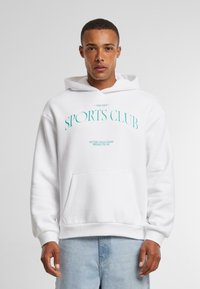 White hoodie with front pocket and ribbed cuffs, featuring light blue text: "ANOTHER SPORTS CLUB, VICTORY BOULEVARD, BROOKLYN, NY."
