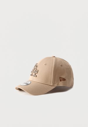 Bež baseball kapa z ukrivljenim šiltom, na sprednji strani pa ima leopardji tisk logotipa »LA« in majhen rjav vezen logotip ob strani.