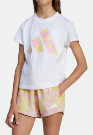 T-shirt bianco in cotone con grafica floreale rosa e gialla e logo. Abbinato a pantaloni corti rosa con motivo floreale e logo.
