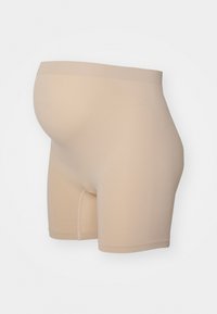 Shorts de maternité beige sans coutures avec une taille extensible conçue pour accueillir un ventre de femme enceinte.