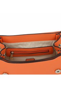 Borsa a mano in pelle arancione con una finitura testurizzata, dotata di un interno chiaro, tasca con zip e bordi neri a contrasto.