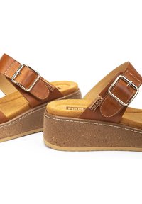 Sandalias de plataforma de cuero marrón con correa ajustable y hebilla de metal, con suela texturizada de corcho y plantilla acolchada.