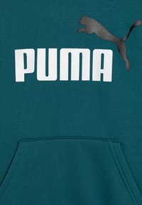 Sudadera color verde azulado con bolsillo tipo canguro, que presenta un gran logo blanco de "PUMA" y una silueta negra de un puma saltando. Textura de tela suave.