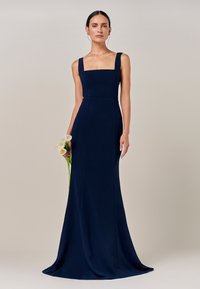 Mornarsko modra obleka do tal s kvadratnim izrezom in širokimi naramnicami. Iz gladkega materiala, z oprijetim zgornjim delom in razširjenim krilom.