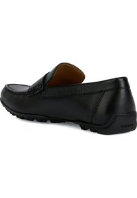 Mocassino in pelle nera con upper testurizzato, punta arrotondata, suola in gomma con piccoli motivi in rilievo e un accento del tallone con marchio.