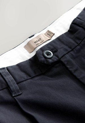 Marine bomuldsbukser med knaplukning, et mærke med teksten "NEXT REGULAR FIT" samt en flad talje med subtil struktur.