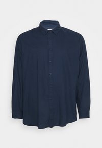 Námořnická modrá košile s dlouhým rukávem vyrobená z měkké látky, s zapínáním na knoflíky, klasickým límcem a pohodlným střihem se zaobleným lemem.