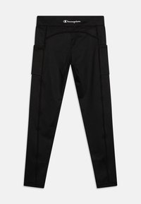 Leggings de sport noirs en tissu extensible, présentant des poches latérales, des coutures plates et une taille avec le logo. Conçus pour le confort et la mobilité.