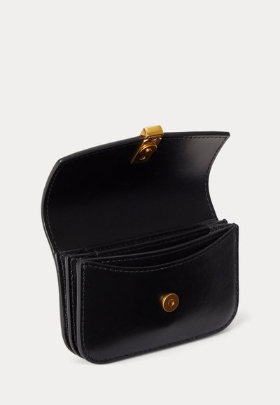 Schwarze Lederbrieftasche geöffnet, um Innenfächer mit einem goldenen Druckknopfverschluss auf weißem Hintergrund zu zeigen.