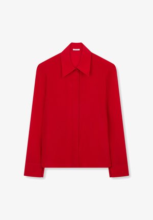 Camicia rossa a maniche lunghe con colletto a punta e patta con bottoni nascosti, mostrata distesa su uno sfondo bianco.