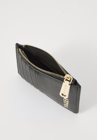 Portafoglio in pelle nera con texture trapuntata, zipper e dettagli metallici in oro. Design compatto con una tasca interna per carte o contante.