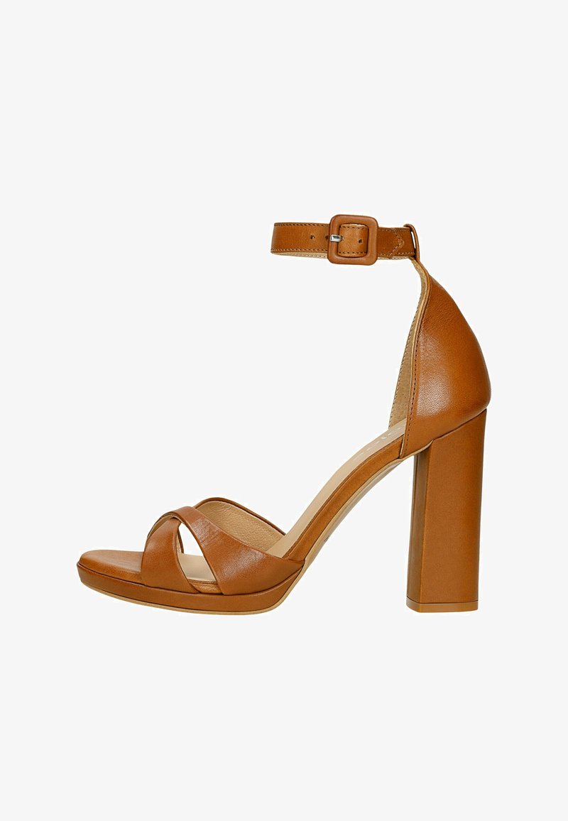 Brown leather heeled sandals with an ankle strap, block heel, crisscross straps over the toe, and a smooth, glossy finish.