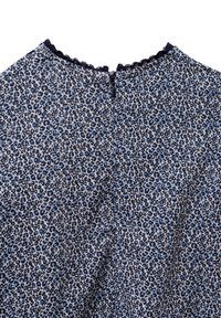 Tessuto blu e nero con un motivo a scallop sul colletto e una zip nascosta sul retro. Presenta un piccolo motivo a stampa leopardata su tutta la superficie.