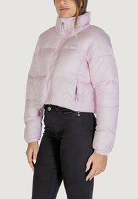 Giacca leggera e cropped in rosa chiaro, con design voluminoso, colletto alto, zip frontale e polsini elasticizzati per una vestibilità aderente.