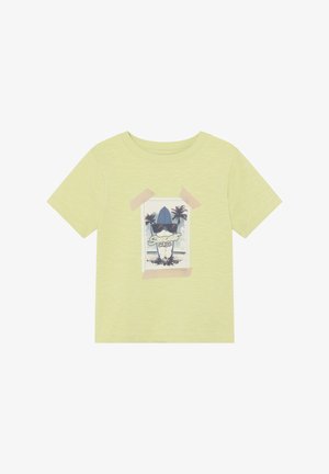 Camiseta de algodón verde claro con un estampado gráfico de una tabla de surf con gafas de sol, rodeada de palmeras y asegurada con detalles de cinta adhesiva.