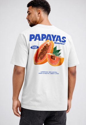 Man wearing white t-shirt with graphic of sliced papayas and text "PAPAYAS Neverless" and product claims on the back.