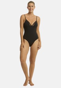 Czarny jednoczęściowy strój kąpielowy z regulowanymi ramiączkami, z przezroczystą siateczkową wstawką i głębokim dekoltem. Gładki materiał i wysoki krój nogawek.