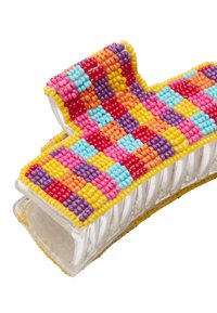 Kolorowy klips do włosów z koralików na przezroczystej podstawie. Charakteryzuje się wzorem szachownicy z różowych, niebieskich, żółtych, pomarańczowych i fioletowych koralików.