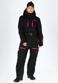 Black ski suit with pink zippers and accents. Features a belted waist and a high collar. Made of waterproof material, designed for winter sports.
