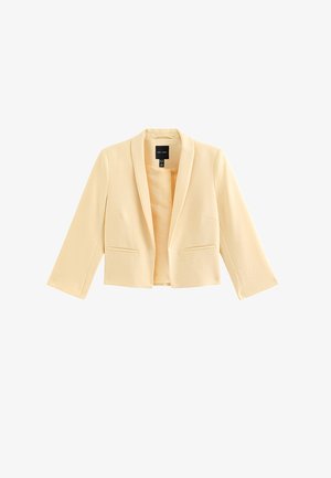 Crèmekleurige cropped damesblazer met lange mouwen, reverskraag en twee voorzakken met openingen, getoond op een witte achtergrond.
