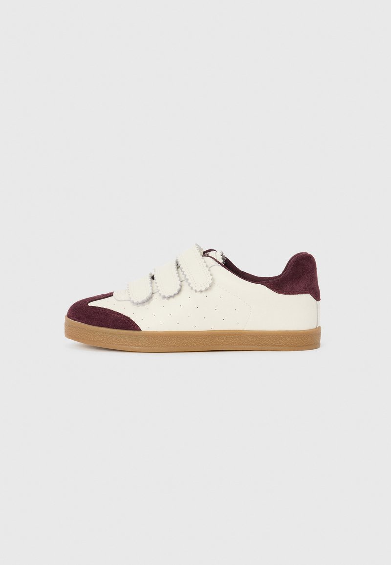 White sneaker with maroon suede accents and three Velcro straps. Features perforations for ventilation and a gum sole. Flat design.
