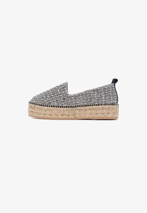 Buty espadryle typu slip-on z czarno-białą plecioną cholewką, grubą plecioną podeszwą na platformie z juty oraz czarną materiałową pętelką z tyłu.