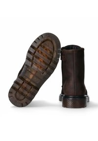 Stivaletti in pelle marrone con suola in gomma texturizzata, tacco basso e cuciture dettagliate. Chiusura laterale con zip e interno imbottito.