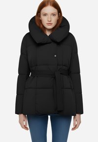 Giubbotto piumino nero con colletto alto e arrotondato, vita con cintura e motivo trapuntato. Presenta maniche lunghe e un accento a bottone sul collo.