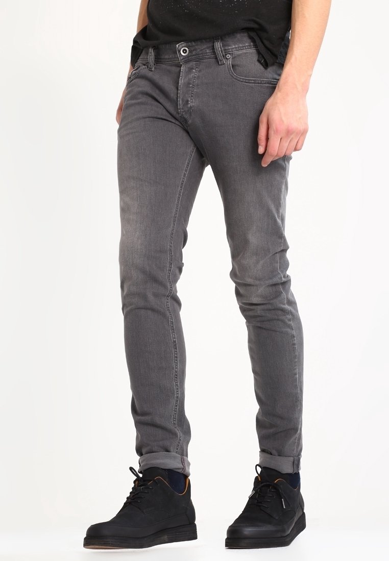 Grå denimjeans med slim fit, med knap- og lynlåslukning, fem fickor och lätt blekning. Bärs med svarta sneakers.