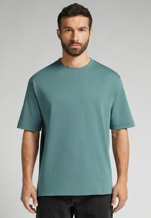 Korte mouw t-shirt in tealkleur, gemaakt van zacht materiaal met een relaxte pasvorm. Heeft een ronde hals en subtiele stikdetails.