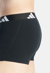 Boxer-briefs noirs en tissu extensible, dotés d'une large ceinture élastique avec des accents de logo de marque blancs et de coutures plates pour le confort.