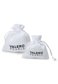 Dva bijela platnena mjenjača s vezicama, na kojima je otisnut tekst "VALERO PEARLS" u crnoj boji. Jedan mjenjač je veći od drugog.