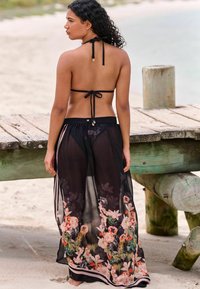 Prozirni crni prekrivač s cvjetnim uzorcima u ružičastoj, narančastoj i žutoj boji, s vezivanjem iza vrata i kontrastnim pojasom.