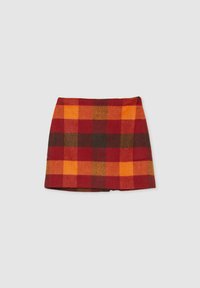 Gonna a scozzese corta nei toni del rosso, arancione e marrone. Realizzata in un materiale morbido con una finitura testurizzata. Presenta una vita semplice e una zip laterale.