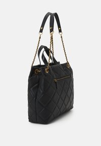 Czarna pikowana torebka z złotymi łańcuszkami, wyposażona w podwójne krótkie uchwyty i przednią kieszeń na zamek. Gładka skórzana powierzchnia.