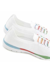 Scarpe sportive bianche realizzate in tessuto a rete, con lacci elastici colorati, una superficie testurizzata e accenti di colore blu, rosso e verde.