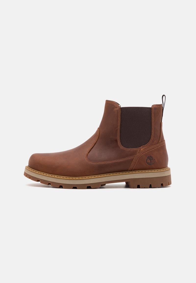 Bottine en cuir marron avec panneau latéral élastique, languette à l'arrière et semelle en caoutchouc beige à crampons. Logo Timberland embossé près du talon.
