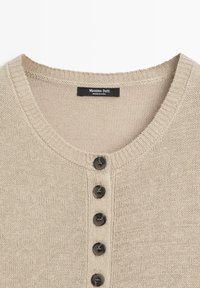 Beige gebreid vestje met vijf zwarte knopen aan de voorkant en een ronde hals, met label Massimo Dutti, gemaakt in China.