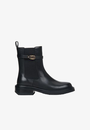 Czarny skórzany botek do kostki z elastycznymi panelami bocznymi, zaokrąglonym noskiem i niskim obcasem typu słupek. Posiada ozdobny pasek ze złotym akcentem.