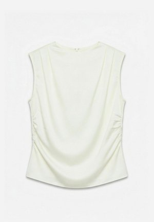 Blouse blanche sans manches avec côtés froncés et petite fermeture éclair au dos, présentée à plat sur un fond blanc.