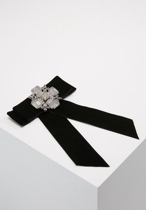Papillon in tessuto nero con code lunghe, adornato con un gruppo centrale di grandi pietre decorative trasparenti e piccole in argento.