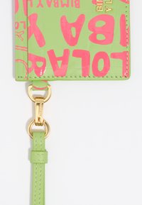 Cartera verde con acabado brillante, que presenta texto en negrita rosa y herrajes dorados. Incluye una correa desmontable de color verde claro para facilitar su transporte.