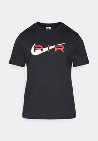 Svart kortärmad t-shirt i bomull. Har en vit Nike swoosh och röd "AIR" text över bröstet. Rund halsringning och vanlig passform.