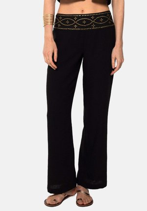Pantalones de pierna ancha negros con una cinturilla decorativa acentuada en oro. Presentan una textura de tela suave y un corte relajado para mayor comodidad y facilidad.