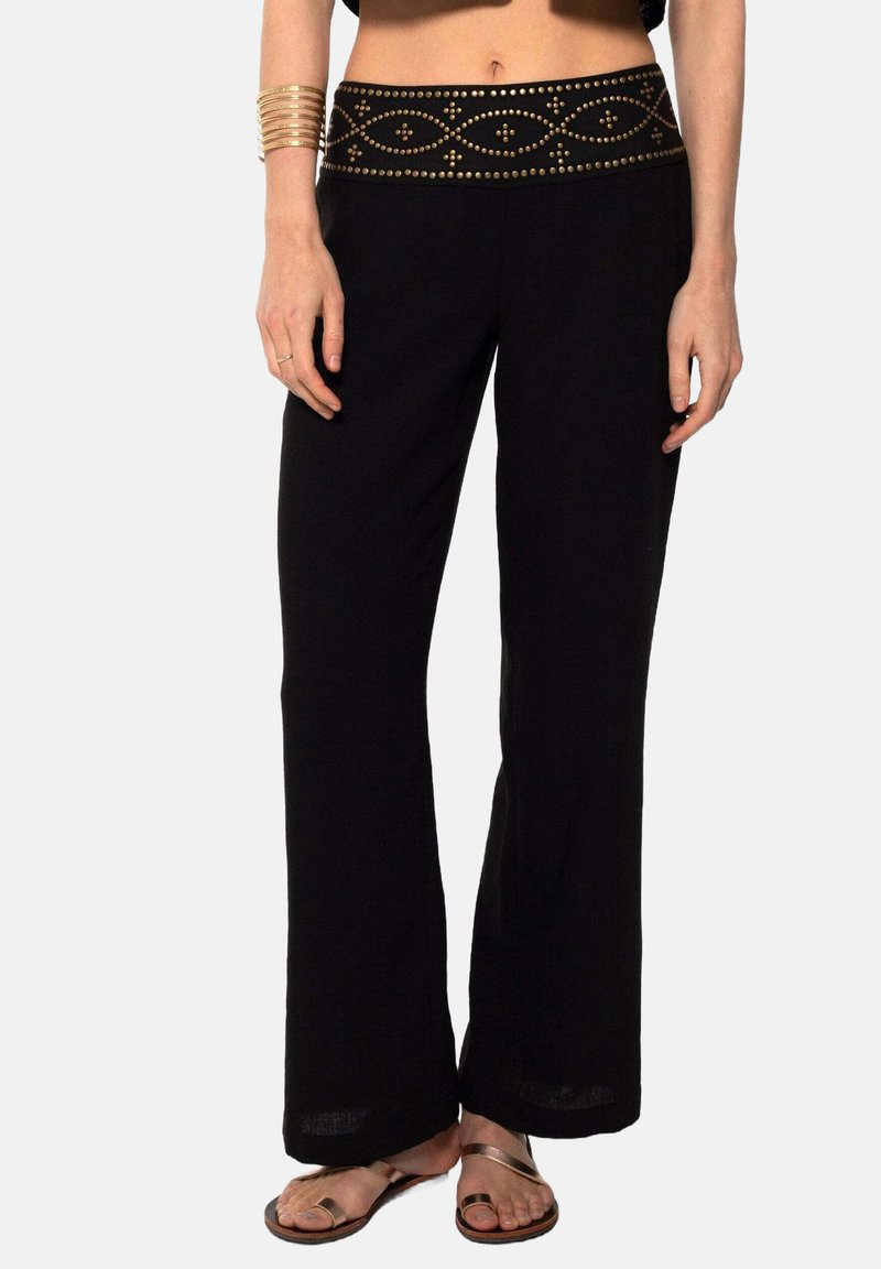 Pantalones de pierna ancha negros con una cinturilla decorativa acentuada en oro. Presentan una textura de tela suave y un corte relajado para mayor comodidad y facilidad.