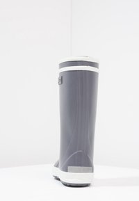 Botte imperméable grise avec une bande blanche en haut, en matériau en caoutchouc, bout arrondi et semelle texturée pour l'adhérence.