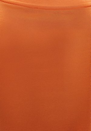 Primer plano de tela de punto acanalada naranja que muestra la textura y detalles de las costuras.