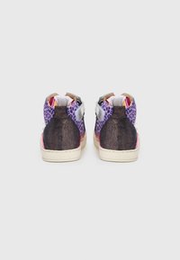 Hochschuh-Sneaker mit lila Leopardenmuster, glitzerndem schwarzen Absatz und kontrastierenden roten und weißen Akzenten sowie Klettverschlüssen.