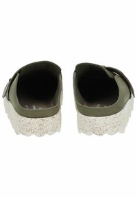 Olive green slip-on shoes with a textured design, featuring a thick white speckled platform sole and a brown leather accent.